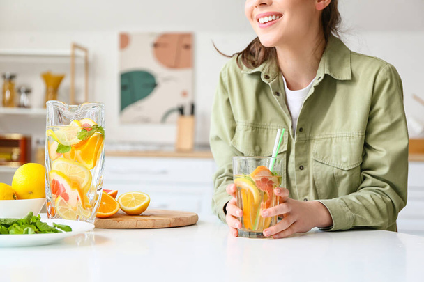 Młoda kobieta pije świeżą lemoniadę w domu - Zdjęcie, obraz