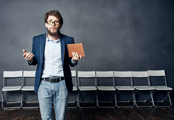 επιχειρηματίας σε ένα κοστούμι κρατώντας ένα σημειωματάριο στα χέρια του επαγγελματική εργασία - Φωτογραφία, εικόνα