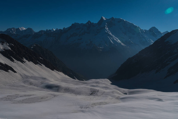 Dramatic view after sunrise during camping and trekking amongst the snow covered Swargarohini mountains under a clear blue sky in the Sankri region of Uttarakhand state, Indian Himalayas. - Φωτογραφία, εικόνα