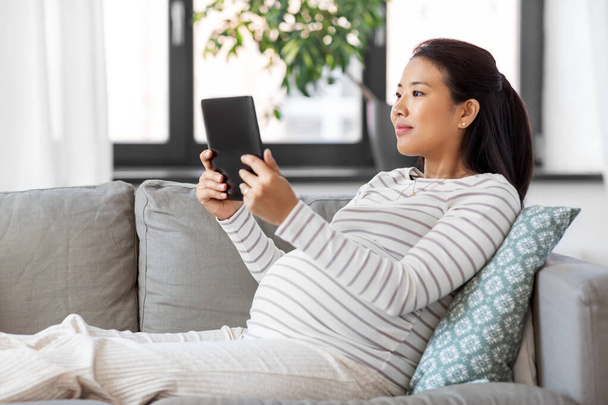 happy pregnant asian woman with tablet pc at home - Фото, зображення