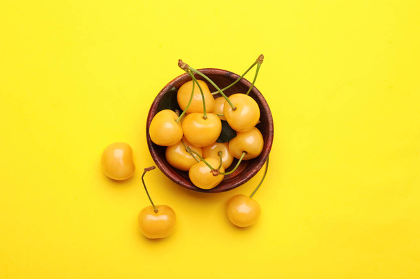 Cuenco con sabrosas cerezas dulces sobre fondo de color - Foto, Imagen