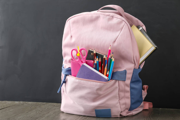 School backpack and stationery near blackboard - 写真・画像
