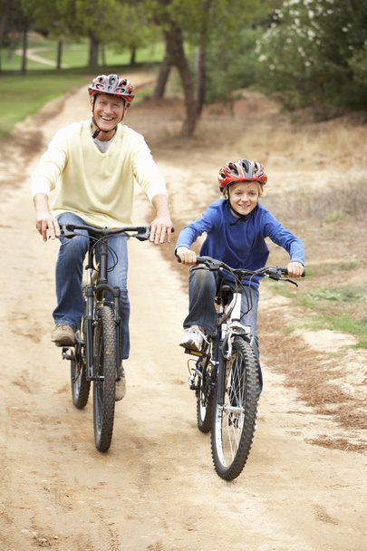 Grandfather and grandson riding bicycle in park - Zdjęcie, obraz