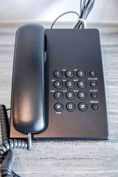 Ένα μικρό σύγχρονο τηλέφωνο για τους πελάτες να τοποθετήσετε στο τραπέζι στο δωμάτιο του ξενοδοχείου - Φωτογραφία, εικόνα