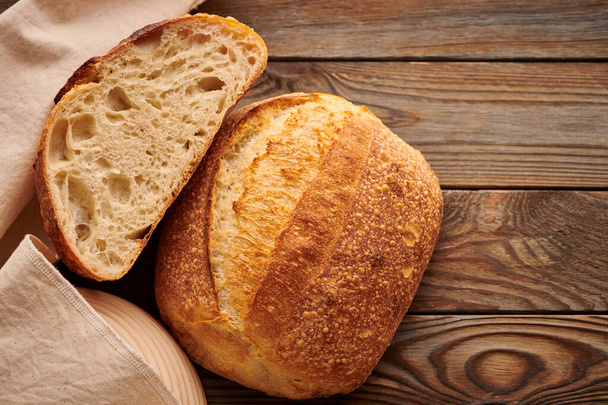 Freshly baked homemade tartine bread on wooden table - Foto, Imagen