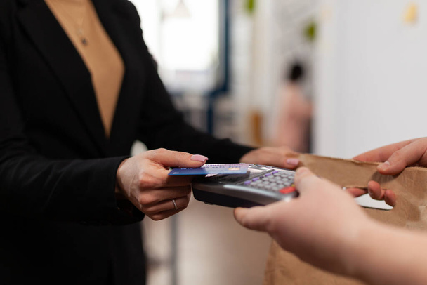 Κοντινό πλάνο της επιχειρηματία που κατέχει πλαστική πιστωτική κάρτα στο χέρι - Φωτογραφία, εικόνα