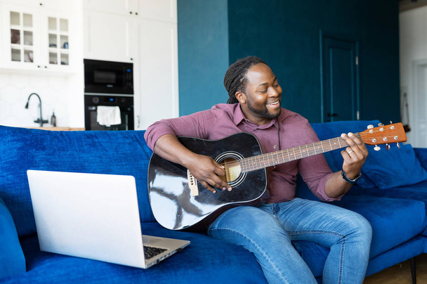 African-American guy playing acoustic guitar and streaming online - Foto, Imagem