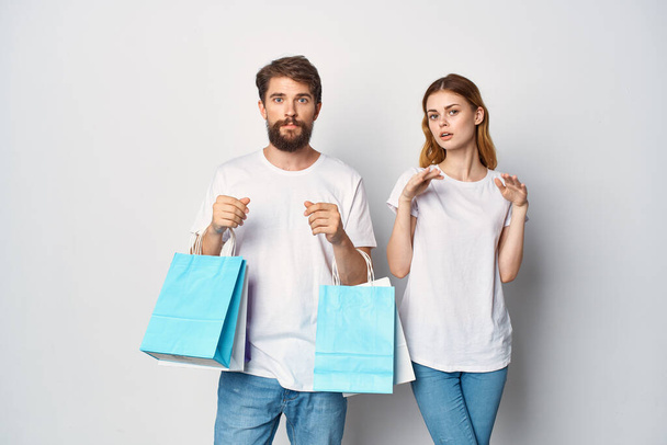 giovane coppia uccisa in t-shirt con pacchetti nelle loro mani stile di vita shopping - Foto, immagini