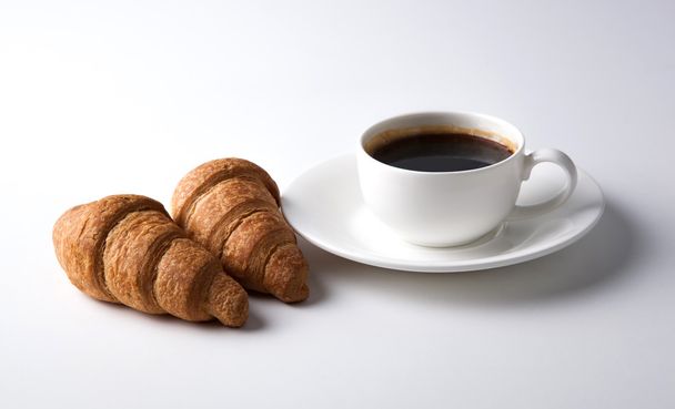 Kuppi mustaa kahvia croissanteilla
 - Valokuva, kuva