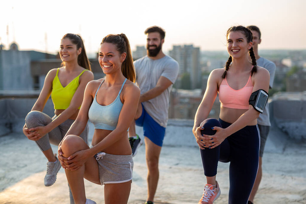 Group of fit happy people training outdoor on the roof - Foto, Imagem