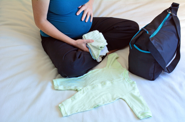 Mujer embarazada empacando una bolsa de hospital
 - Foto, imagen