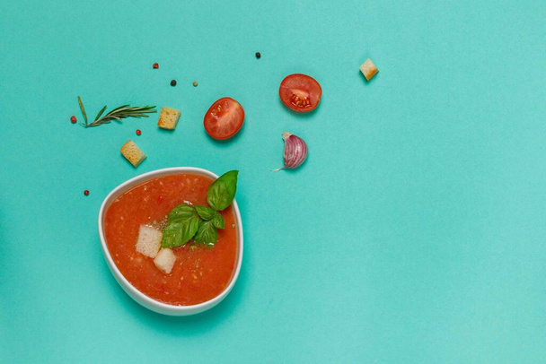 Fesleğenli soğuk domates çorbası, kızarmış ekmek ve taze vejetaryen püresi çorbası. İspanyol mutfağı. Yeşil arkaplanda düz bir arkaplan, yatay, boşluğun bir kopyası - Fotoğraf, Görsel
