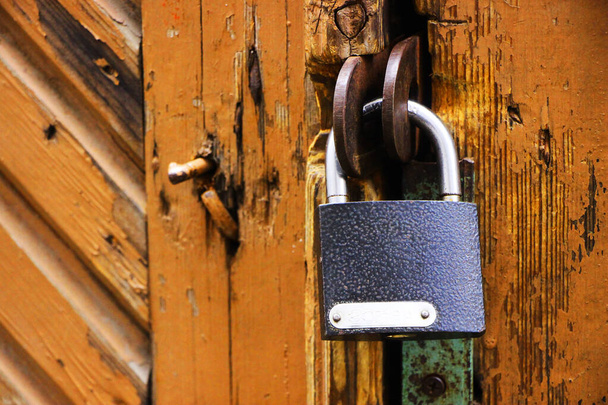 Hanging vintage padlock on locked old door - Photo, image