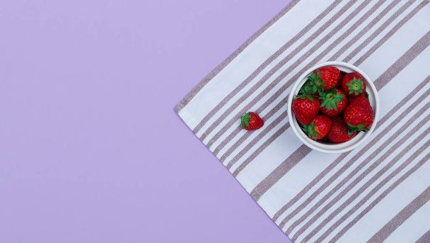 キッチンタオルでイチゴとボウルのトップビュー。生の夏の食のコンセプト. - 写真・画像