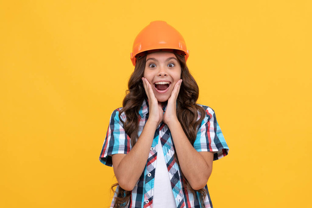 amazed kid with curly hair in construction helmet, engineer - Photo, Image