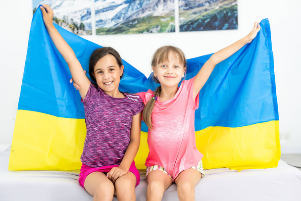 niños portan banderas ondeantes de Ucrania. Día de la Independencia Ucraniana. Día de la Bandera. Día de la Constitución. Chicas con bandera de Ucrania - Foto, Imagen