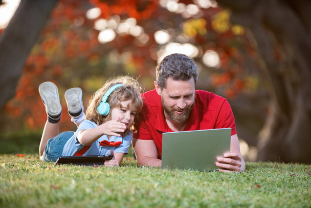 père et fils utilisent la technologie de communication moderne dans le parc. blog de famille. - Photo, image