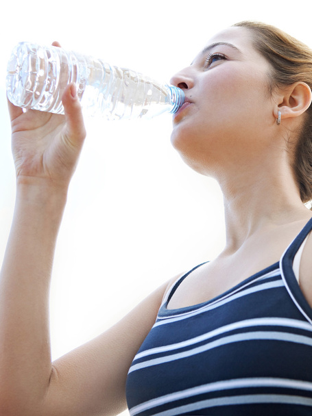 Frau setzt sich hin und trinkt Mineralwasser - Foto, Bild
