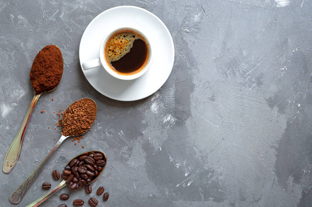 Különböző típusú kávé. Kávébab, őrölt és instant kávé a kanalakban és egy csésze friss eszpresszó. Felülnézet, másolás. - Fotó, kép