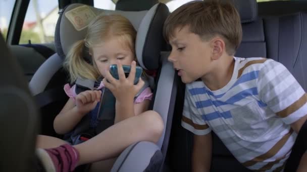 車の中で携帯電話を持つ子供のビデオ。8Kでレッドヘリウムカメラで撮影. - 映像、動画