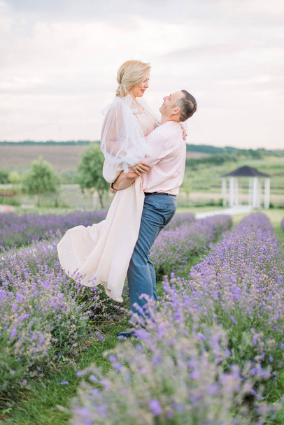 Happy middle aged couple in a field of purple lavender - Fotoğraf, Görsel