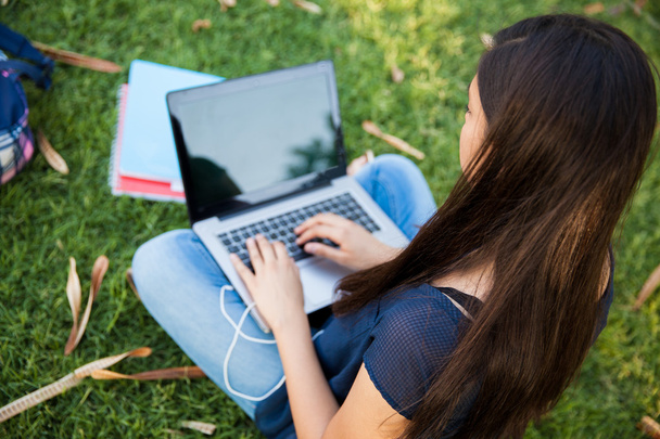 Teenager using a laptop - Фото, изображение