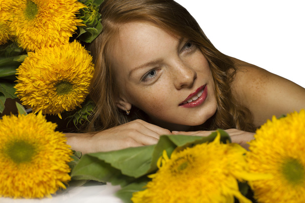 roodharige vrouw met gele bloemen - Foto, afbeelding