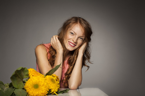 rothaarige junge Frau mit gelben Blumen - Foto, Bild
