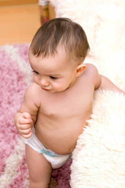 Cute caucasian baby near the bed - Foto, afbeelding