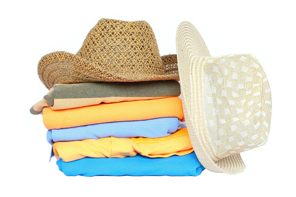 Montón de ropa colorida con un sombrero sobre fondo blanco
  - Foto, imagen
