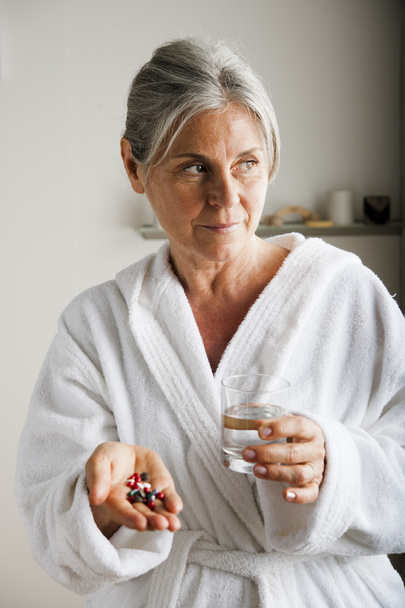 Senior woman with pills and water - Fotó, kép