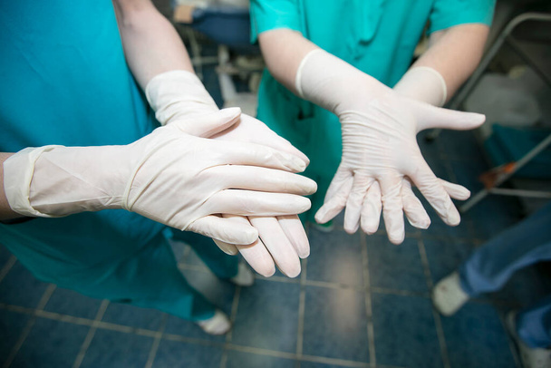 Lekarze w gumowych rękawiczkach leczą ręce przed operacją. - Zdjęcie, obraz