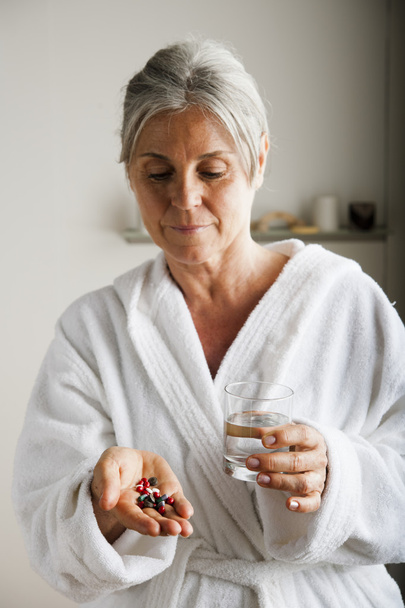 Senior woman with pills and water - Фото, зображення