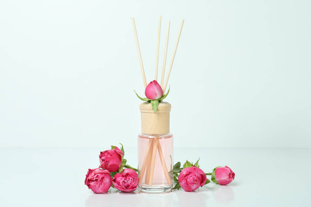 Diffuser en roze rozen op witte achtergrond - Foto, afbeelding