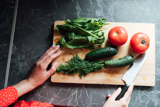 美しい女性主婦は台所で野菜のサラダを作る - 写真・画像