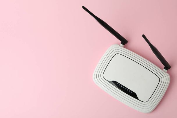 WLAN-Router mit externen Antennen auf rosa Hintergrund - Foto, Bild