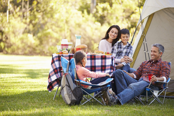 Family Enjoying Camping Holiday In Countryside - 写真・画像