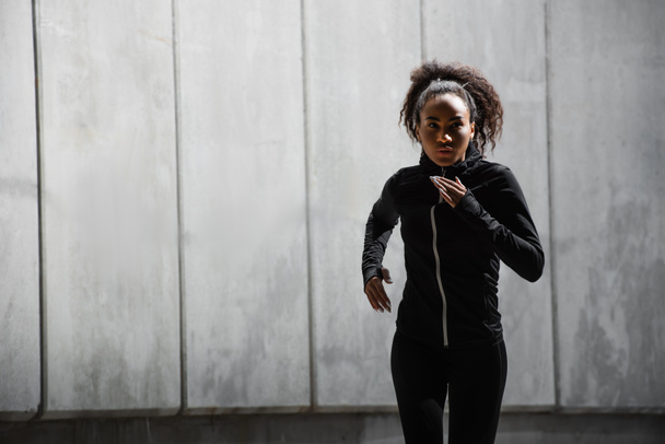 Αφροαμερικανή γυναίκα τρέχει κοντά στο κτίριο  - Φωτογραφία, εικόνα