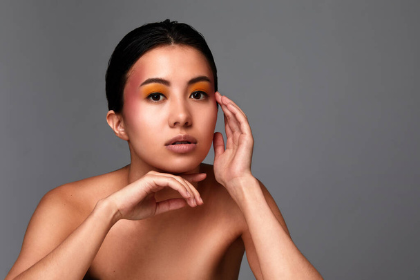 Portré egy szépség ázsiai lány, gyönyörű női arc tiszta és egészséges bőr, közelkép egy szürke háttér, másolás tér - Fotó, kép