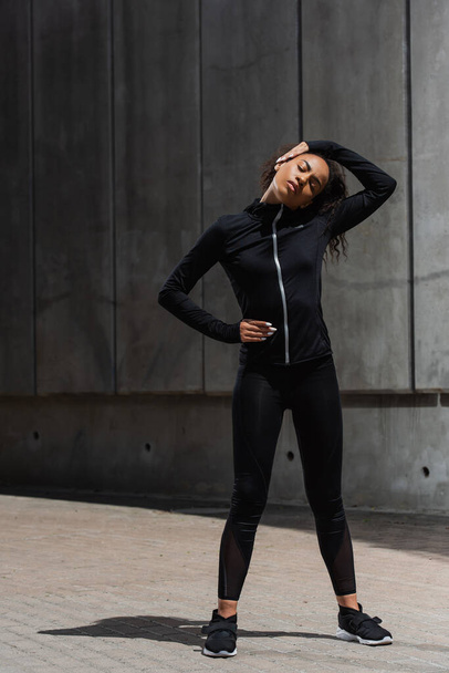 African american sportswoman stretching before work out outdoors  - 写真・画像