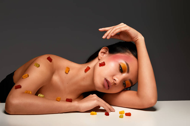 Schönheitsporträt eines Mädchens mit Marmelade, Asiatin mit schönem Gesicht und gesunder Haut, mit Marmelade, Schönheitskonzept. - Foto, Bild