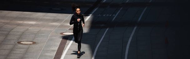 Deportista afroamericana corriendo en pista, estandarte  - Foto, Imagen