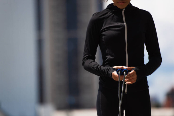 Cropped view of african american sportswoman holding skipping rope outdoors - Zdjęcie, obraz