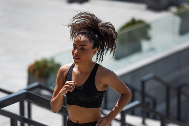 African american sportswoman in top running on urban street  - Foto, immagini