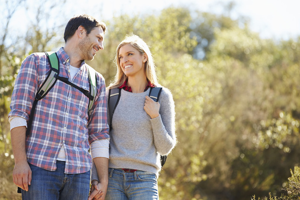 Couple Hiking In Countryside Wearing Backpacks - Foto, Imagem