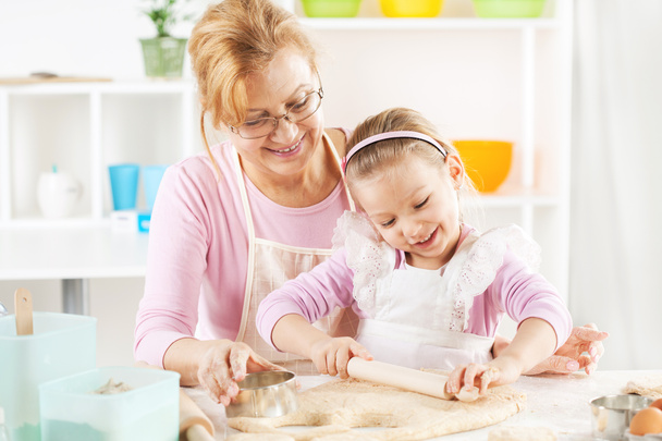 Бабуся і онука роблять тісто
 - Фото, зображення