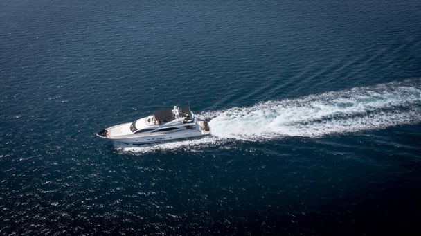 Вид с воздуха на роскошную яхту-катер, плавающую в глубине океана, символ богатства и роскошных путешествий. - Фото, изображение
