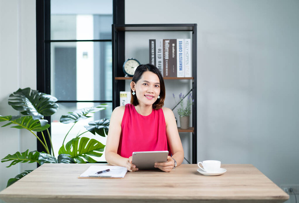 Азиатская деловая женщина представляет бизнес-отчет через видео-звонок на домашнем ноутбуке. Бизнесмен или предприниматель, работающий, интернет-магазины, электронная коммерция, интернет-банкинг, работающий от концепции дома - Фото, изображение