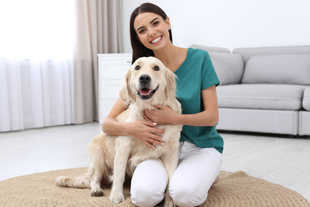 Happy woman with her cute pet dog at home - Фото, изображение