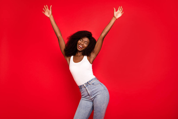 Photo of young excited african girl happy positive smile have fun enjoy hands up music dance isolated over red color background - Photo, Image